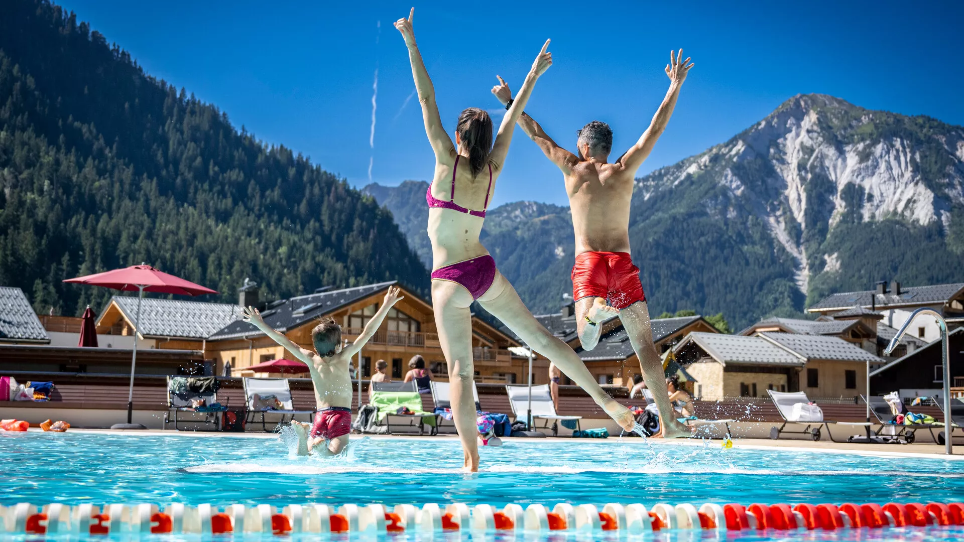 Famille qui saute dans la piscine